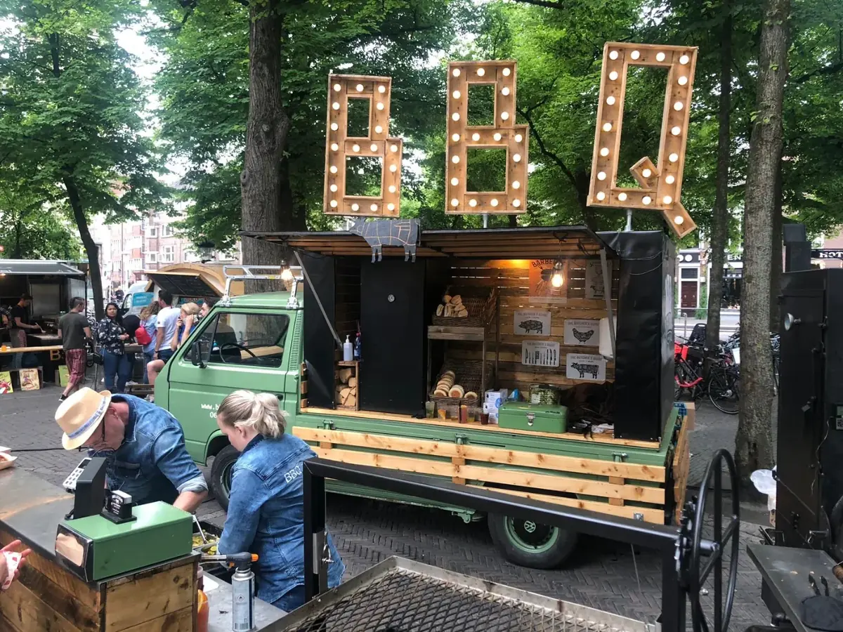 De BBQ-truck met lichtletters op een evenement