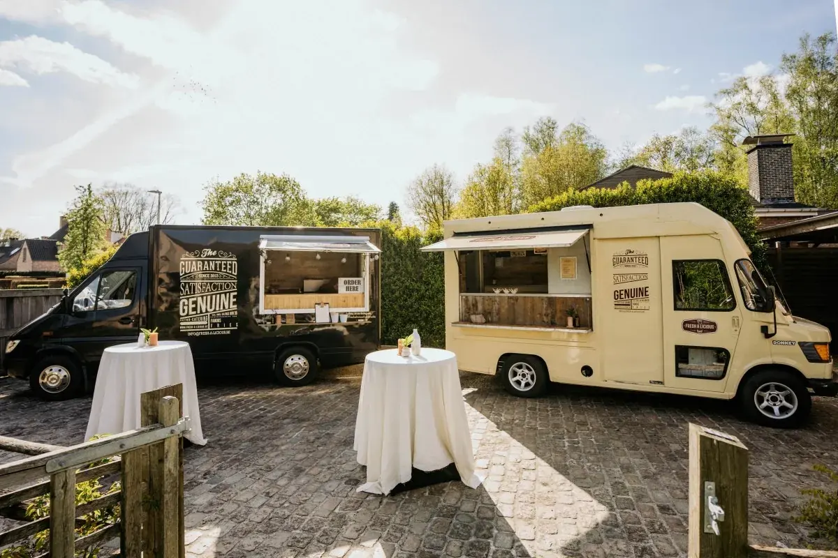 Twee retro foodtrucks van Fresh-A-Licious op een tuinfeest, te huur via Feestkarhuren.nl