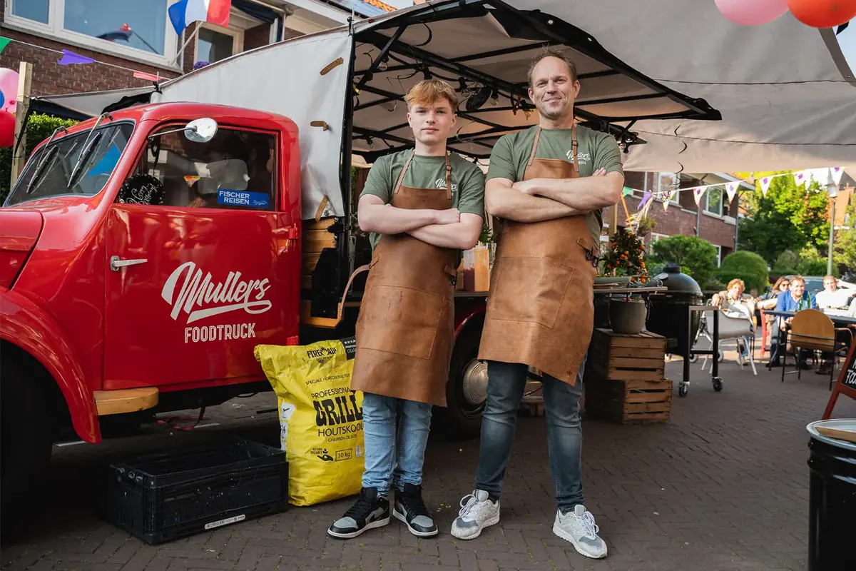 Het team van Mullers Foodtruck bij de rode foodtruck, te huur via Feestkarhuren.nl