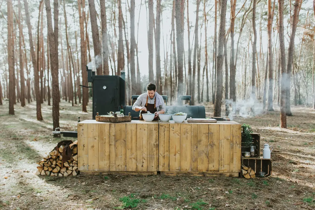 De BBQ-opstelling van Rook en Vee met de smoker in het bos, te huur via Feestkarhuren.nl