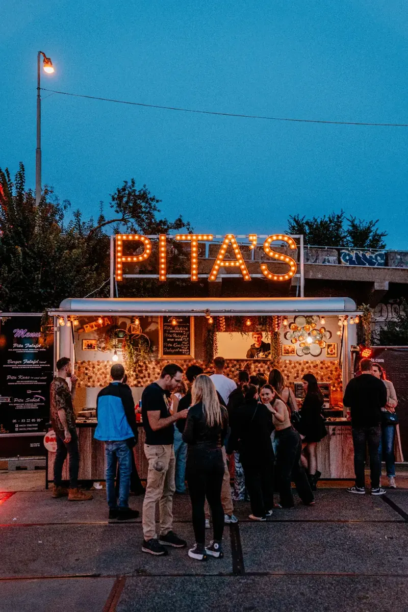 De foodtruck van Sabich Streetfood ’s avonds met gasten, te huur via Feestkarhuren.nl