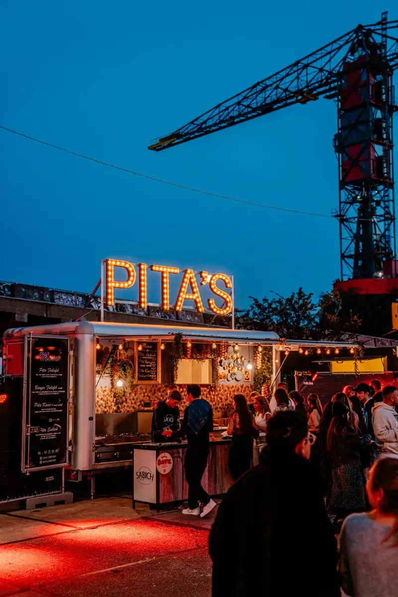 De foodtruck van Sabich op een festival bij avond