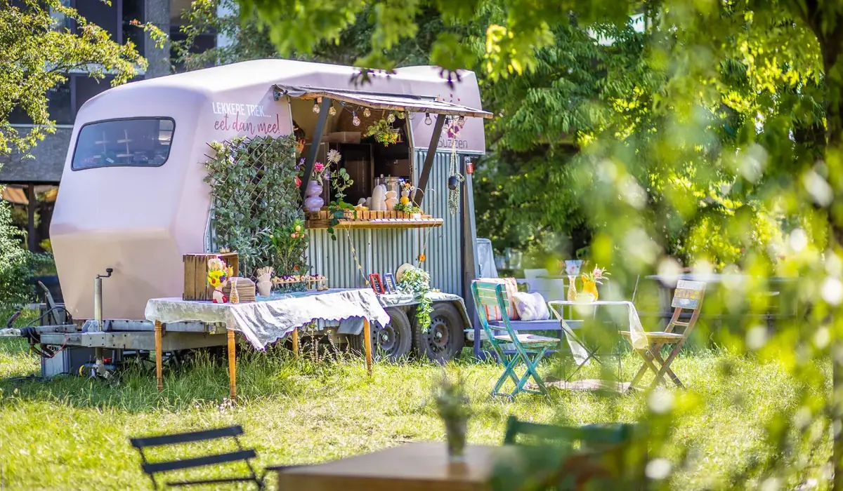 De foodtruck van Suzzen in een tuin, te huur via Feestkarhuren.nl
