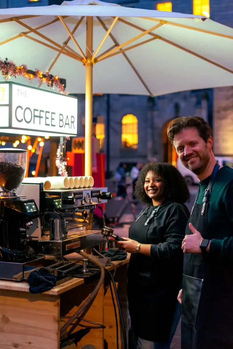 Een barista van The Coffee Car schenkt koffie