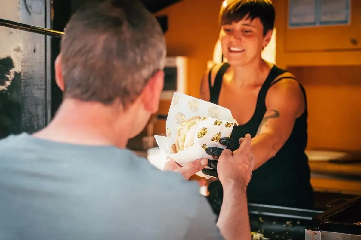 Een burger wordt aan een gast gegeven bij The Rollin'Burger