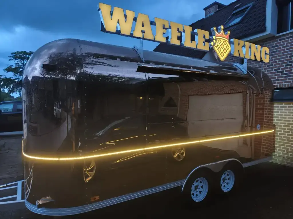 De koninklijke koets van WaffleKing met verlichte naamletters, te huur via Feestkarhuren.nl