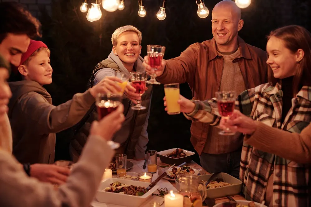 Gasten aan een lange gedekte tafel in de avond