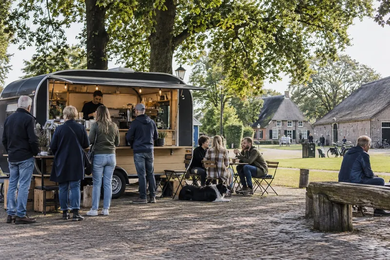 Koffiekar op de brink van een esdorp met oude boerderijen, Drenthe