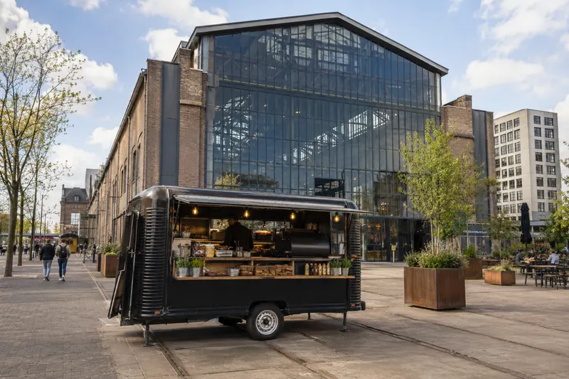 Barbecuetruck in de Spoorzone in Tilburg voor de glazen gevel van de LocHal